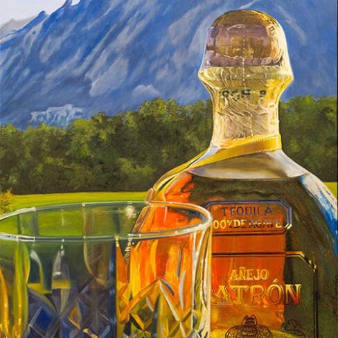 Monica Marquez Gatica's painting depicting a detailed Patron Añejo tequila bottle next to a crystal glass with the Flat Iron mountains in the background.