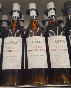 Three bottles of Lustau VORS Sherry, showcasing Oloroso, Palo Cortado, and Amontillado varieties.