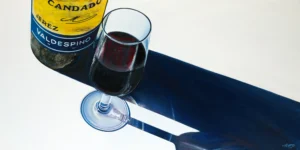 Realistic acrylic and oil painting of a Jerez Sherry wine bottle and glass casting a long shadow on a canvas.