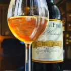 A glass of sherry and a bottle of Cayetano del Pino Palo Cortado Solera on a table at Gallo Azul in Jerez, Spain, with warm sunlight casting a golden glow