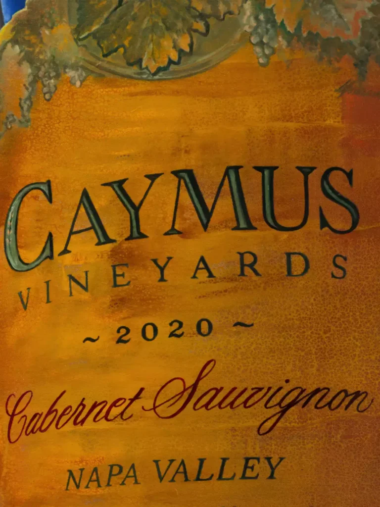 Close-up of Caymus bottle label in 'A Perfect Moment' painting by Monica Marquez Gatica