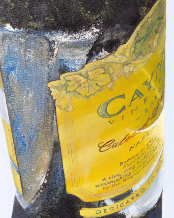 Close-up of the Caymus wine label, showcasing intricate textures created by fluid acrylic pouring, with vivid yellow hues and detailed grapevine leaves.