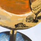 Close-up of a golden wine glass in Monica's painting, revealing the fluid acrylic pouring technique in the reflective surface of the glass.