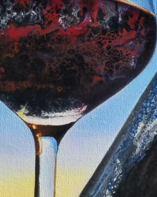 Close-up of a glass of red wine, showing deep red hues and intricate reflections of the sunset within the glass.