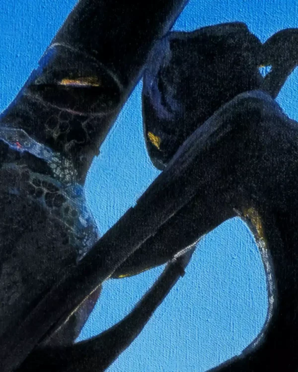 Close-up of a silhouette of a wine bottle and a sculpture, framed against a vibrant blue sky in the background.