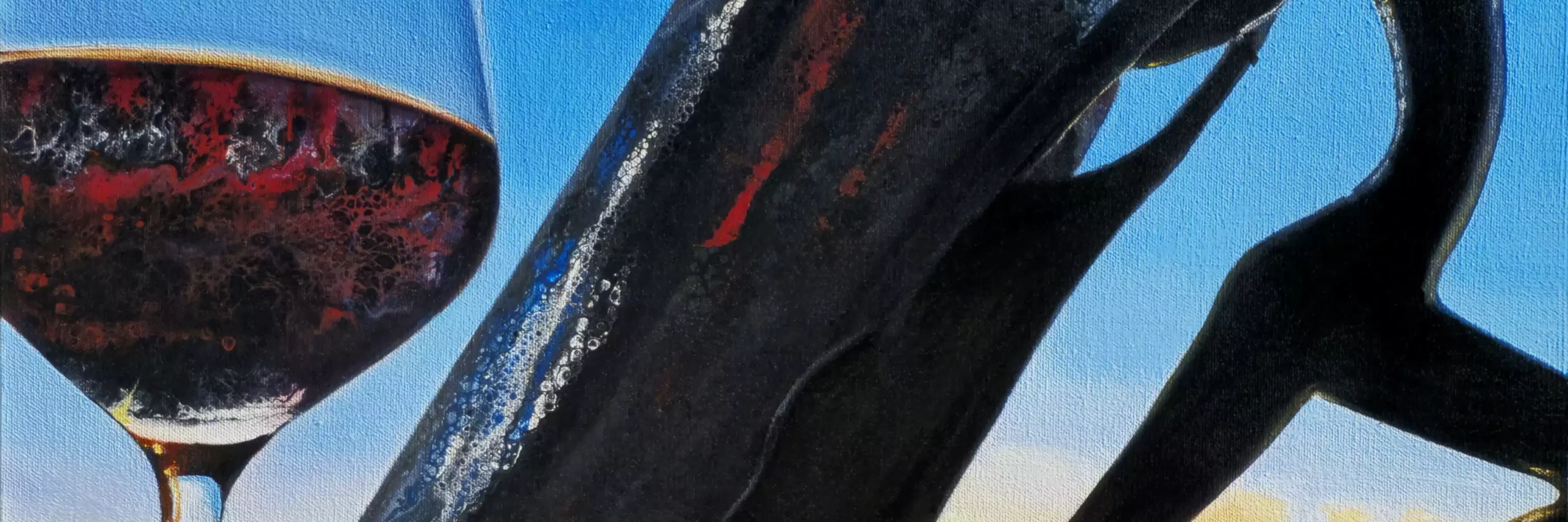 Close-up of a glass of red wine and a silhouetted wine bottle reflecting the vibrant colors of a sunset against a clear blue sky.