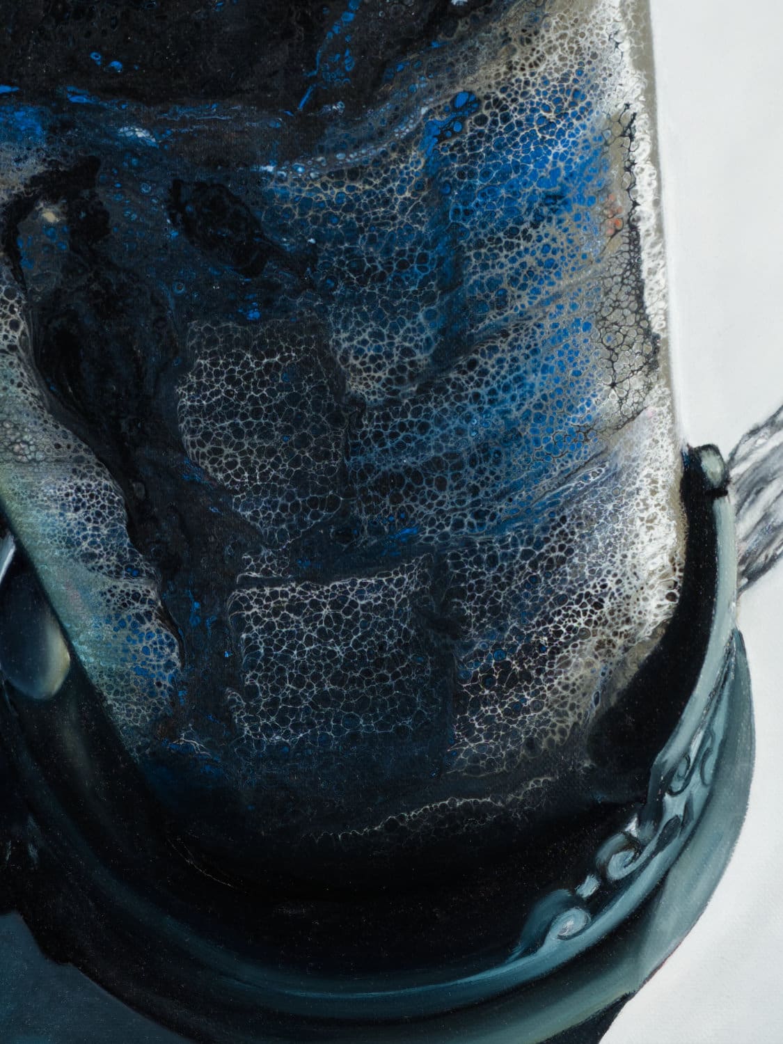 Close-up of textured wine bottle with deep blues and intricate detailing.