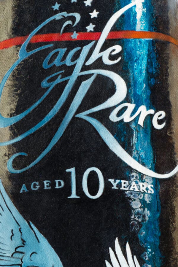 Close-up of the Eagle Rare logo and label on the painting "Spirit of the Soar," with intricate oil painting details over a textured acrylic pour