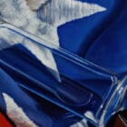 A close-up of the bottle’s neck and cap, with the American flag’s stars and stripes reflecting in the glass.